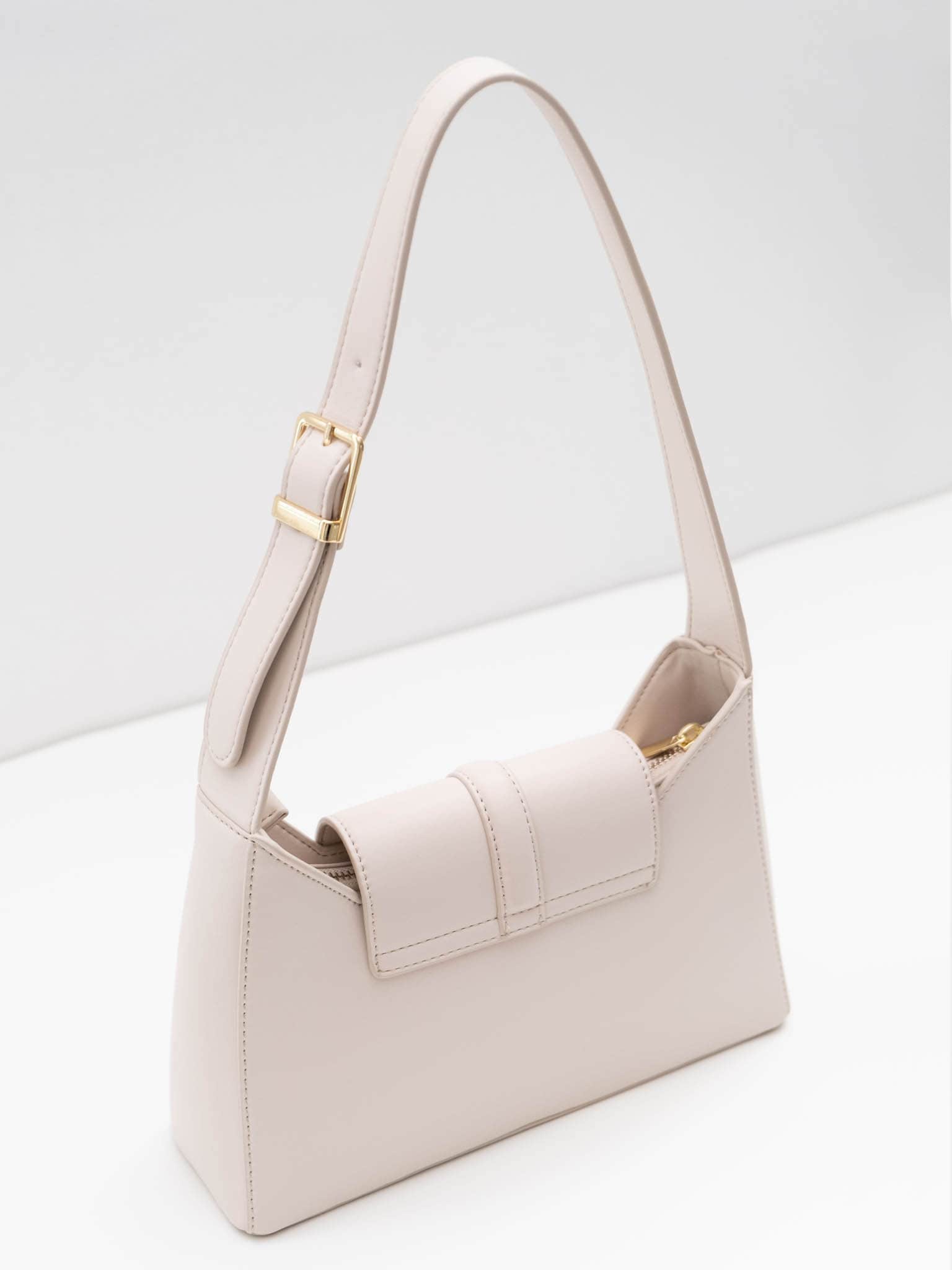 Trapeze-shaped bag with wide shoulder strap