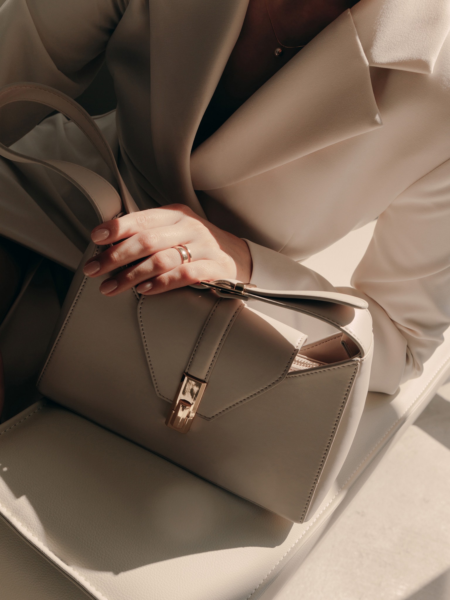 Trapeze-shaped bag with wide shoulder strap