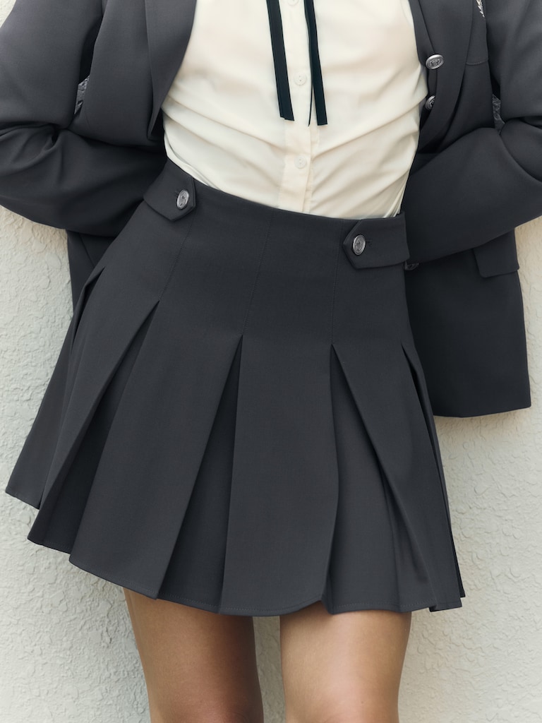 Mini pleated skirt with metal buttons on the waistband
