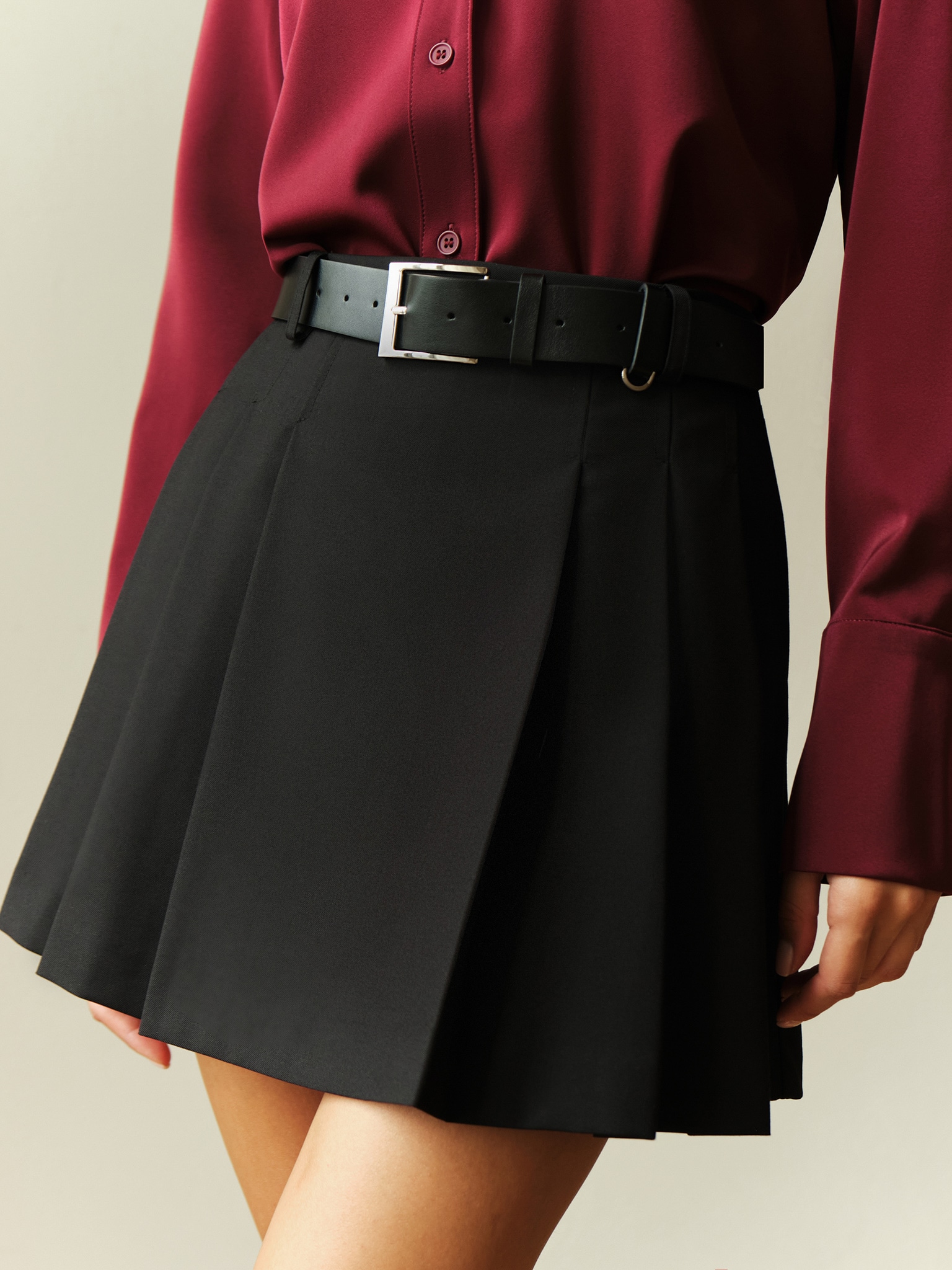 Mini skirt with large pleats on the sides and a belt