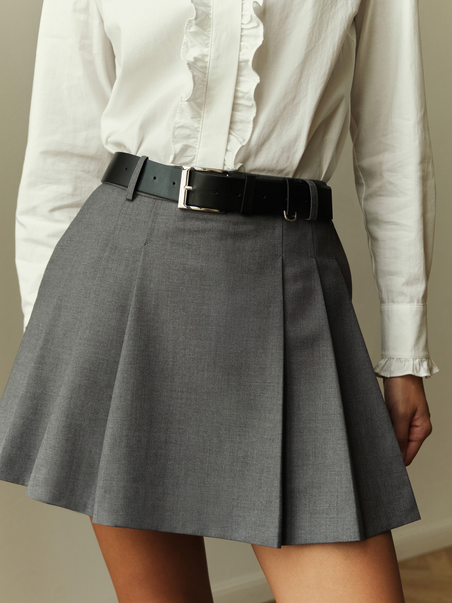 Mini skirt with large pleats on the sides and a belt