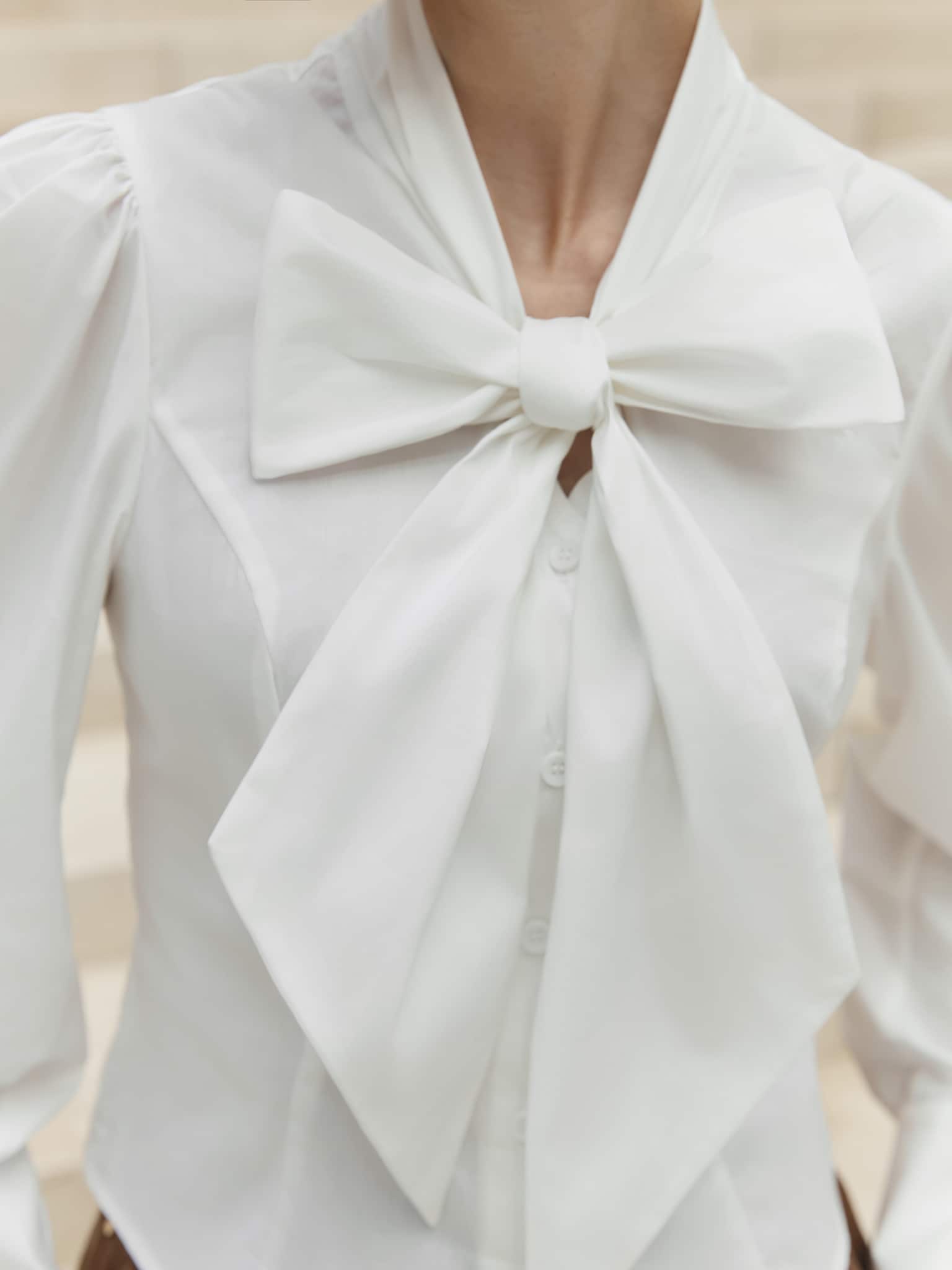 Dopasowana bluzka z kokardą przy kołnierzu