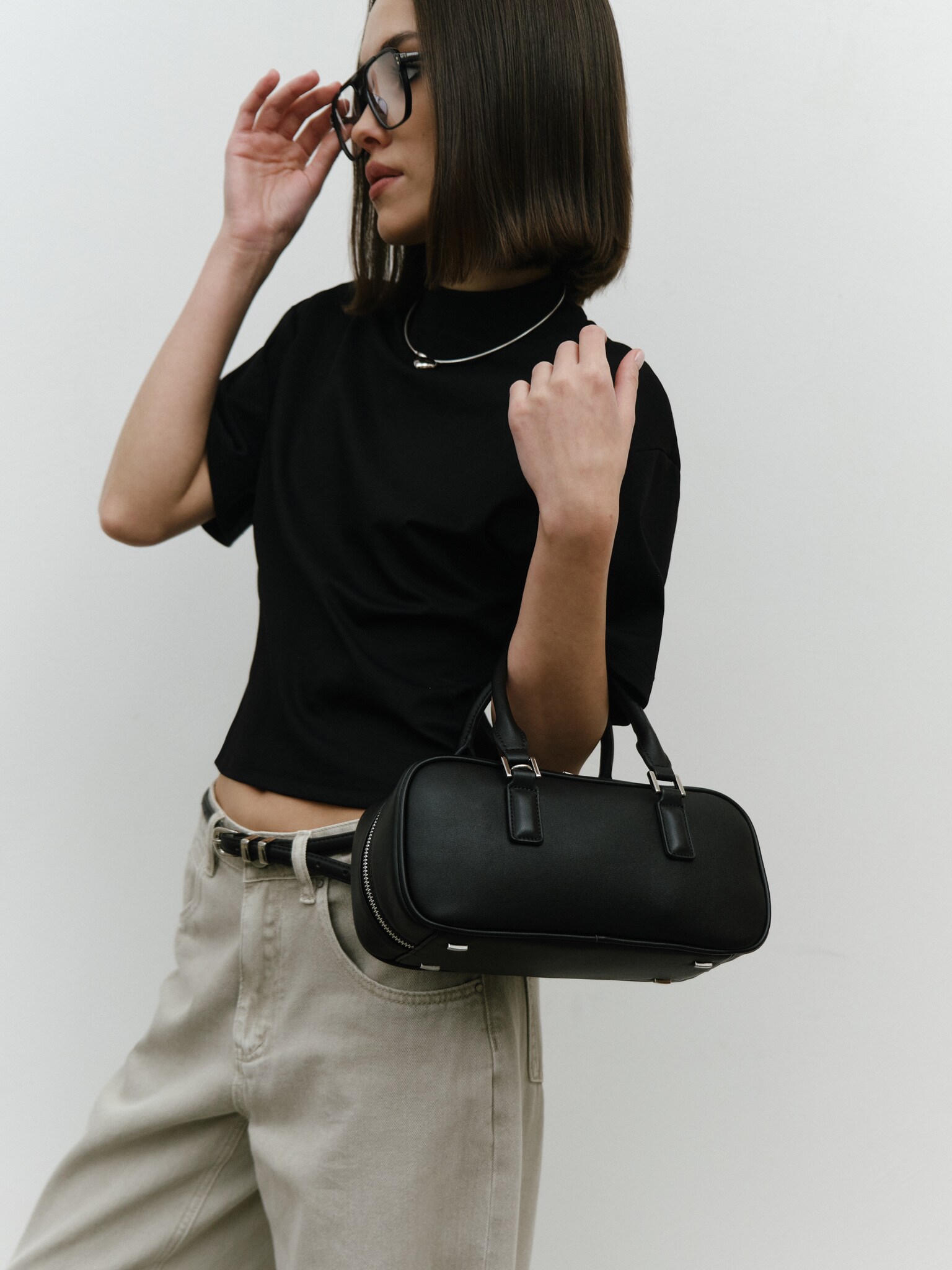 Rigid-shaped bag with short handles and a strap