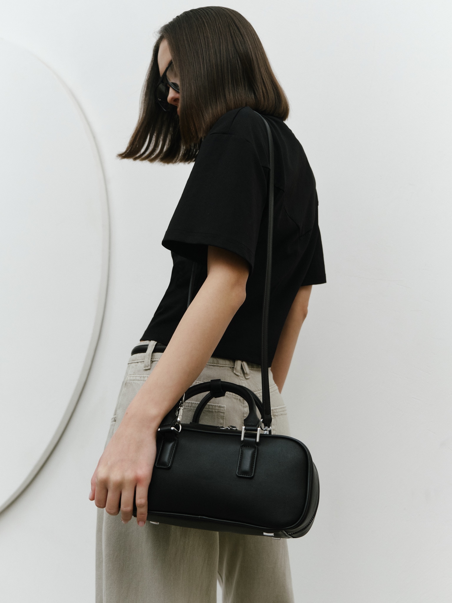 Rigid-shaped bag with short handles and a strap