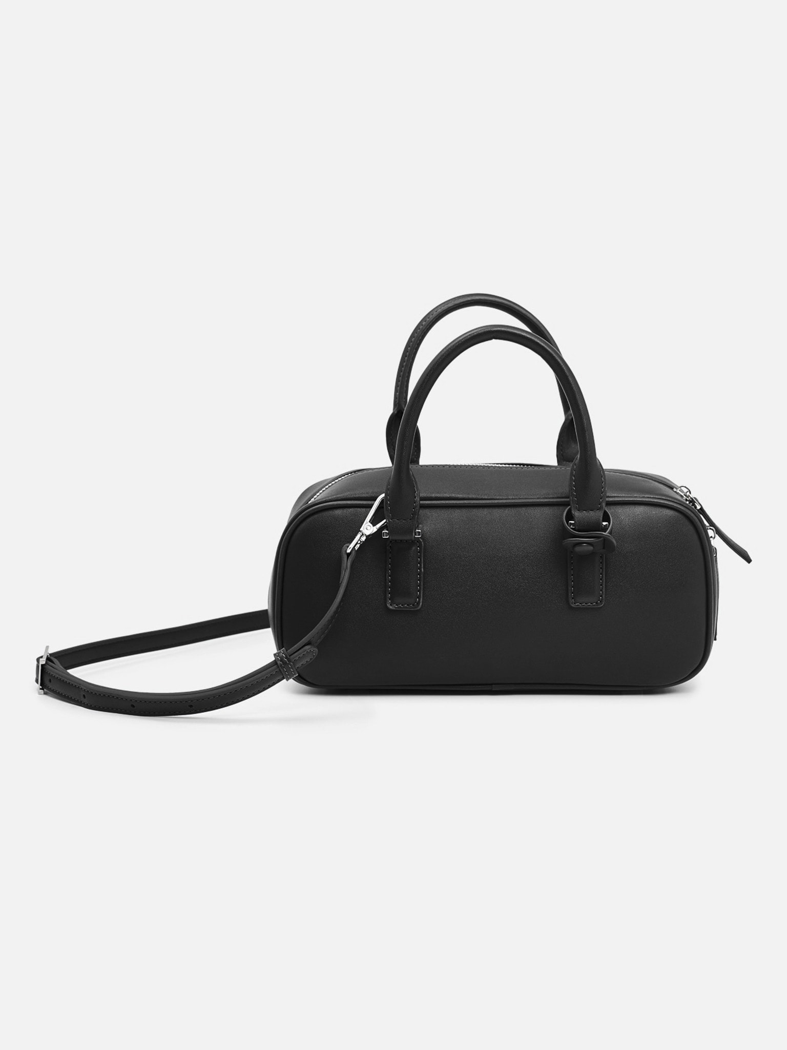 Rigid-shaped bag with short handles and a strap