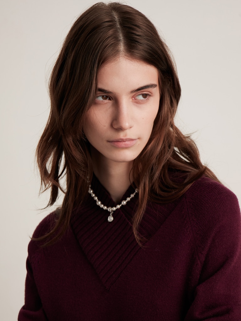 Колье из бусин разного размера с подвеской в стразах