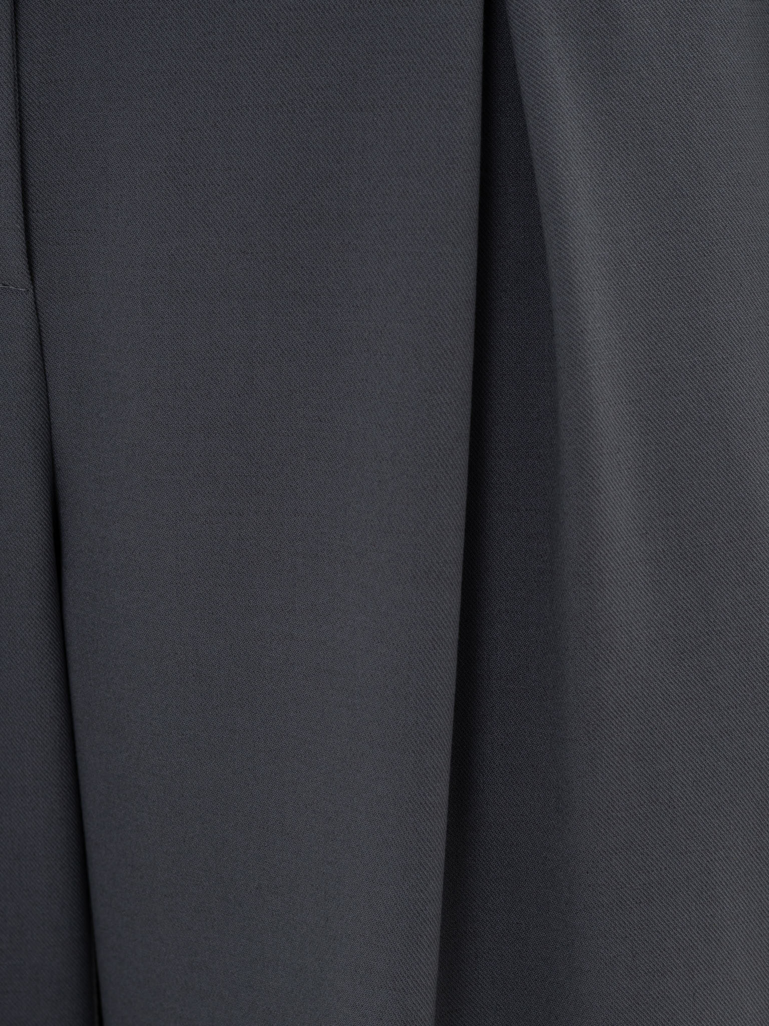 Loose-fit trousers with draping at the hips