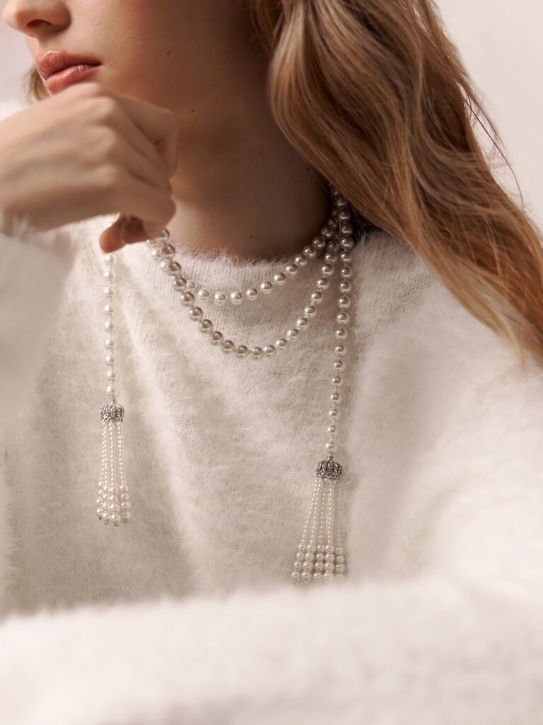 Long pearl strand with pendants at the ends