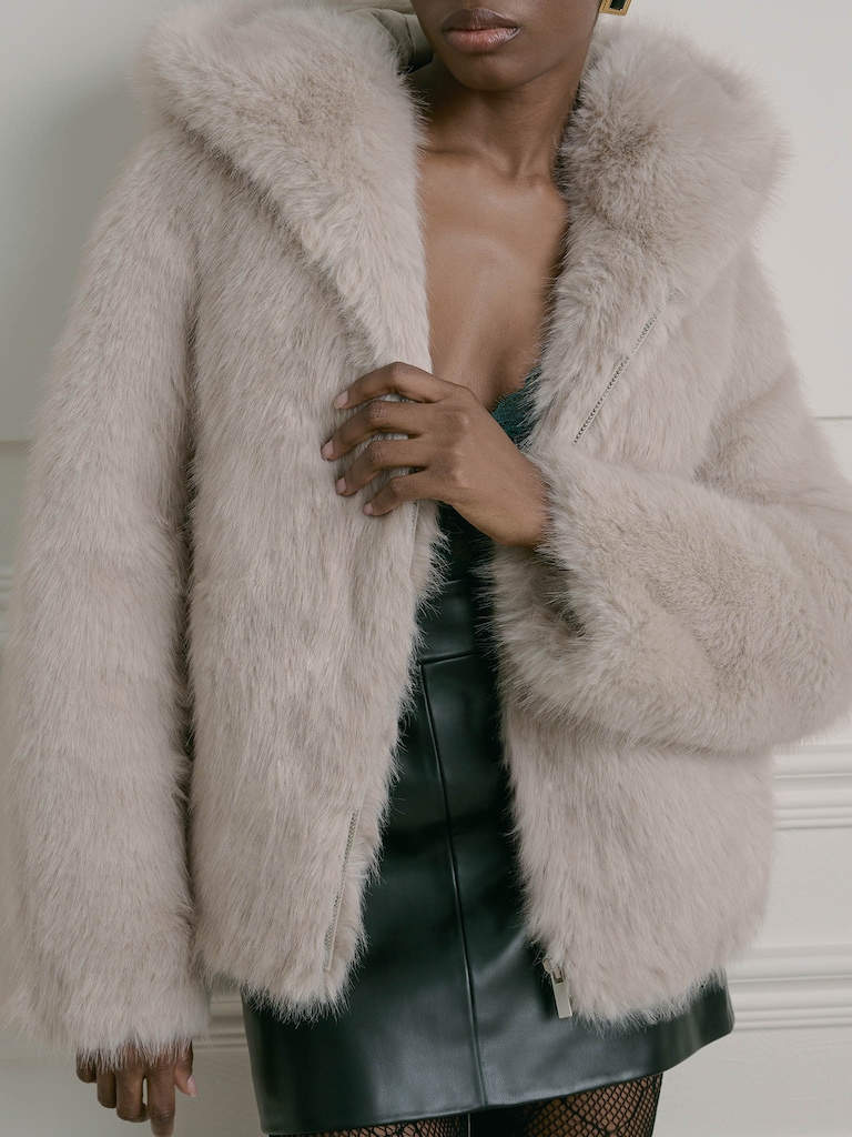 Manteau court en éco-fourrure avec une fermeture éclair et une capuche