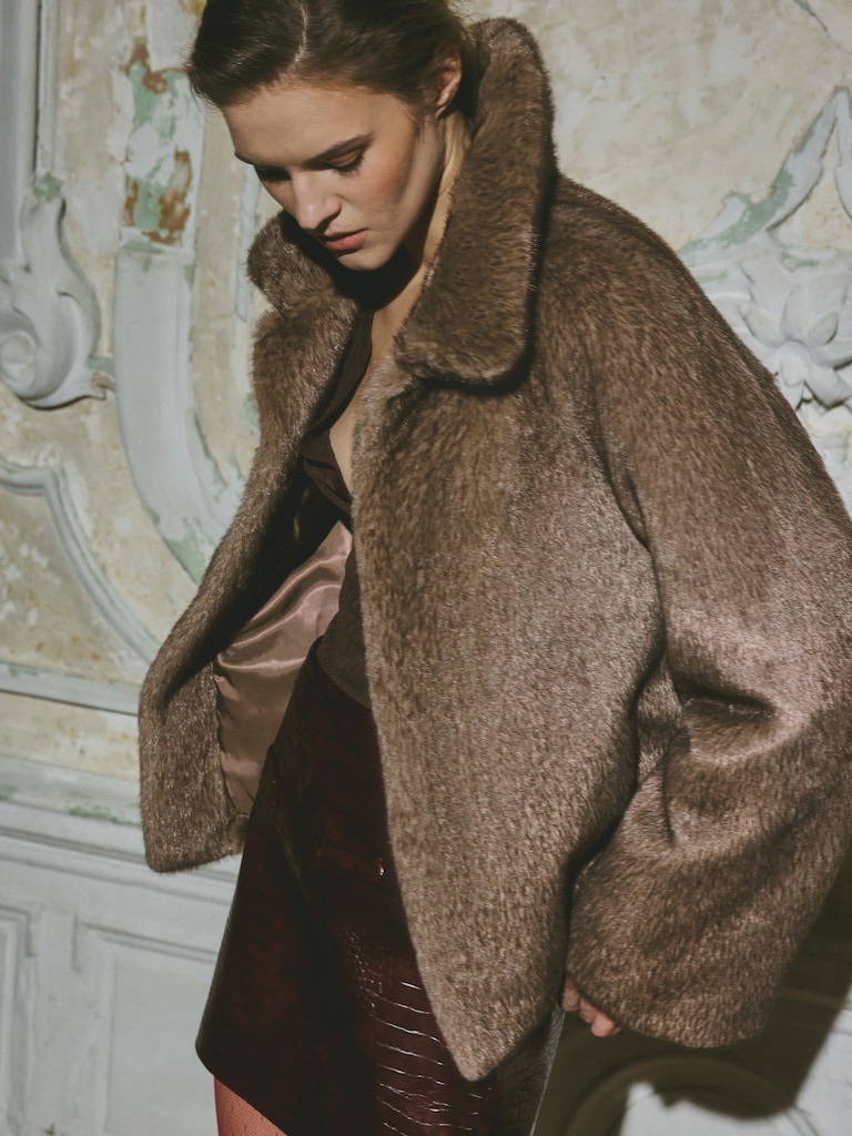 Manteau court droit en éco-fourrure avec col triangulaire