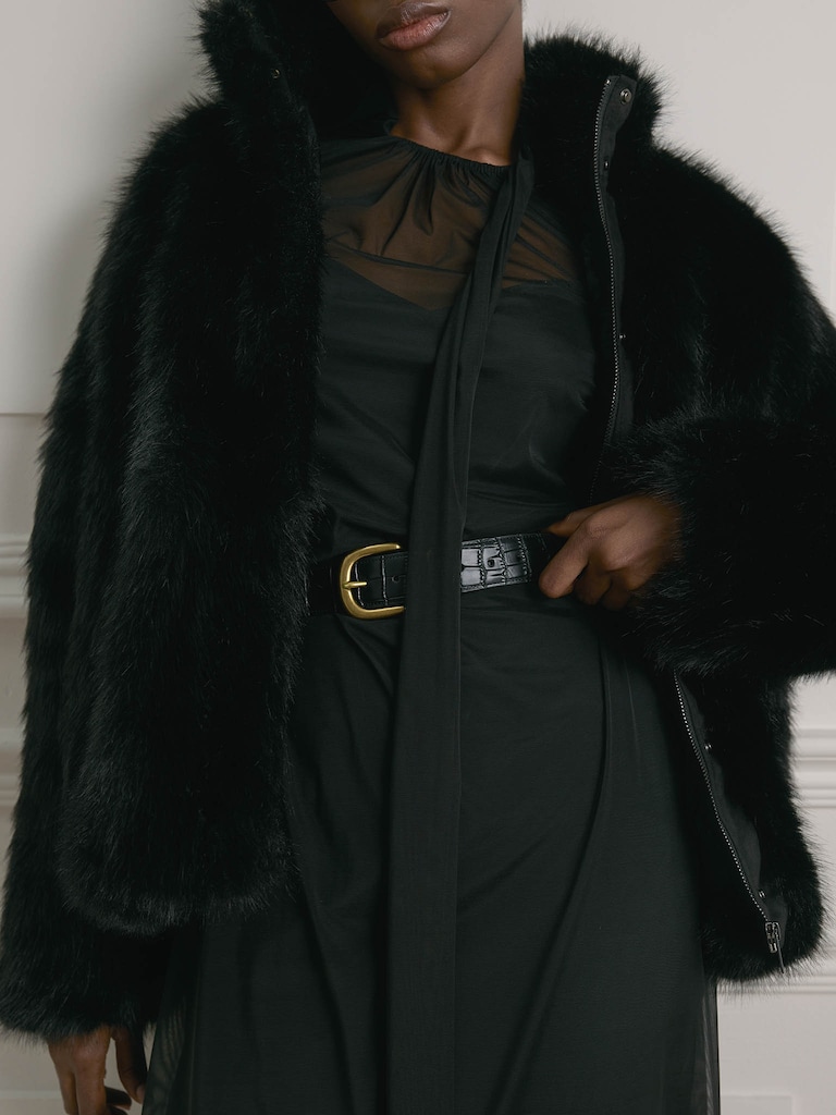 Manteau court en éco-fourrure avec fermeture zippée et col montant