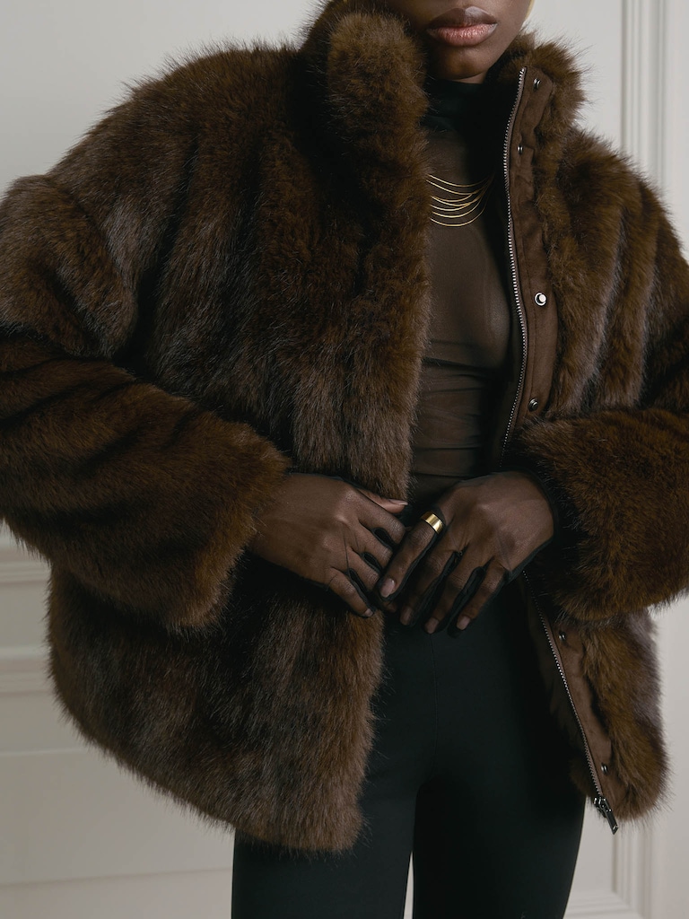 Manteau court en éco-fourrure avec fermeture zippée et col montant