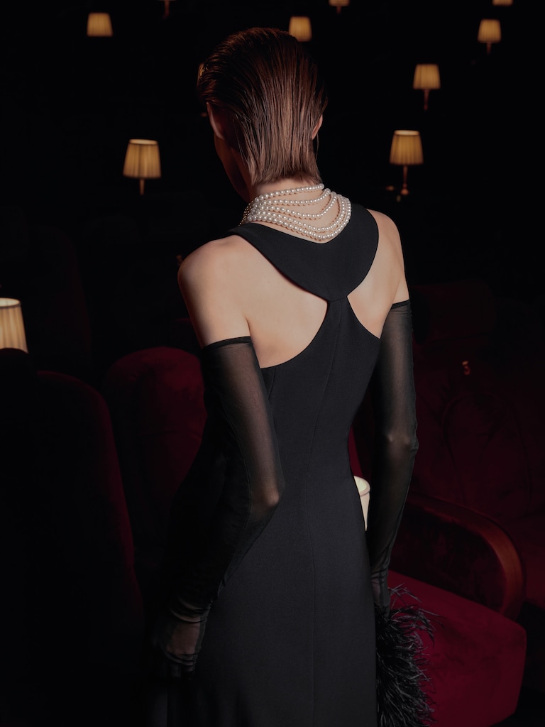 فستان ماكسي بفتحات في الظهر وعقد من اللؤلؤ